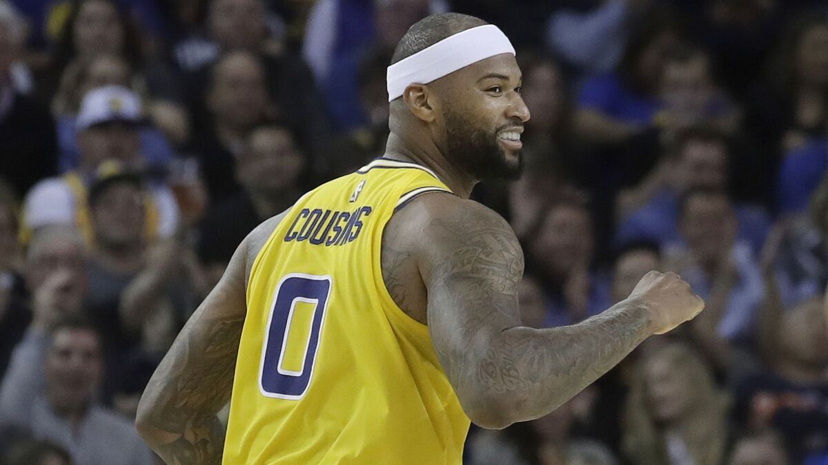 Golden State Warriors center DeMarcus Cousins smiles after scoring against the Denver Nuggets in 2019.