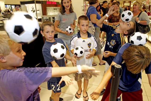 Members of Huntington Beach's AYSO Region 56 boys soccer entertain themselves as they wait in line to see Landon Donovan of the L.A. Galaxy.