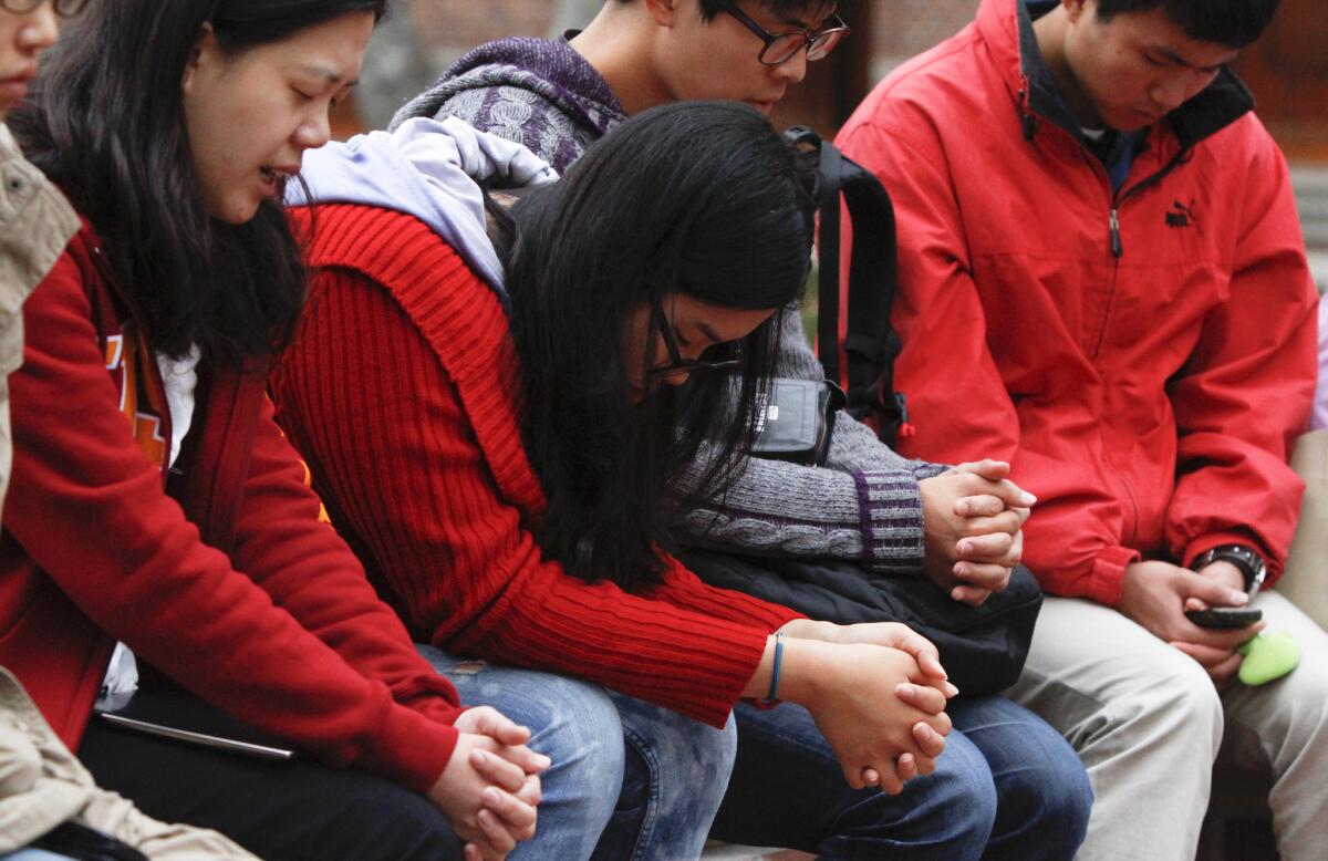 USC students, sitting near the site of the Halloween party shooting, pray for the safety of the campus the day after the shooting occurred.