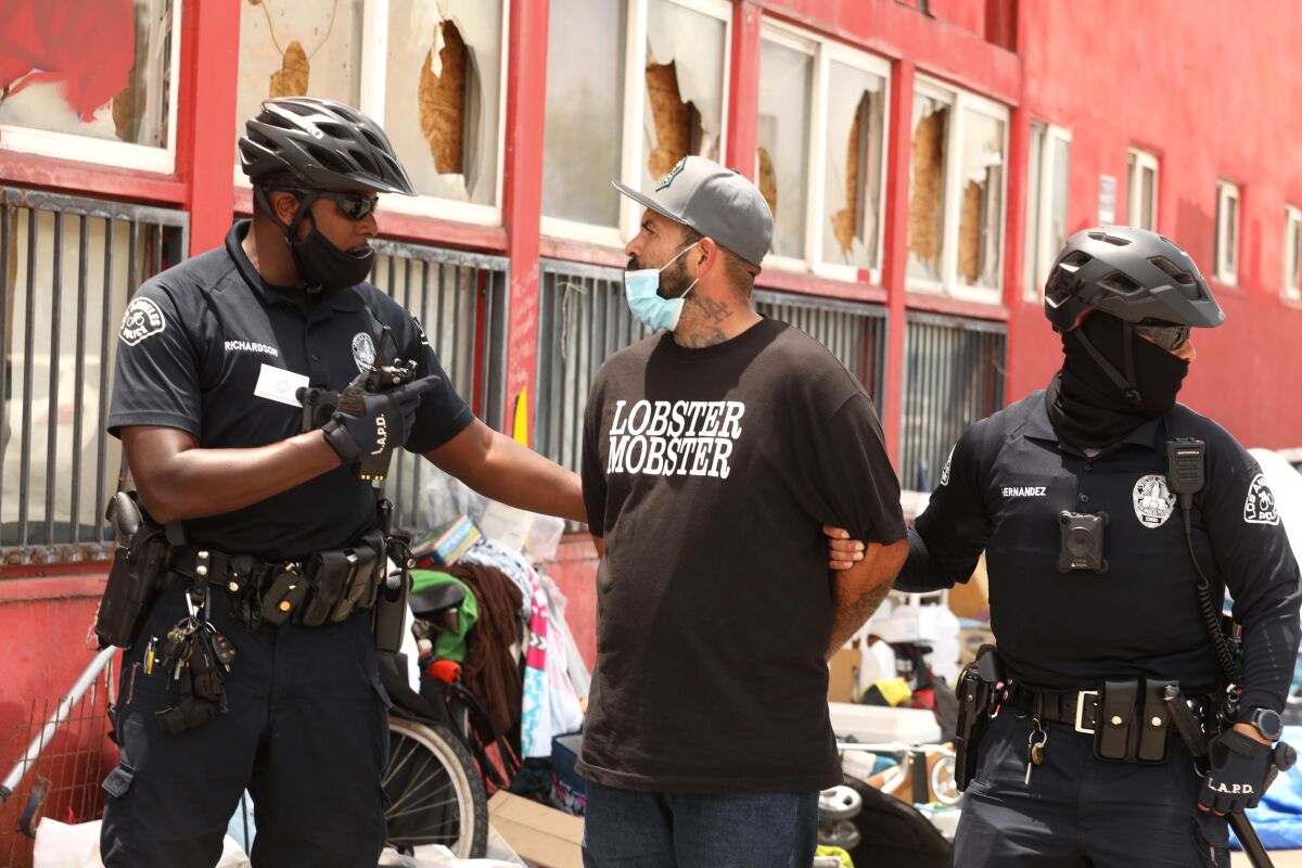 Police officers detain a man during a June 2 march in Los Angeles.