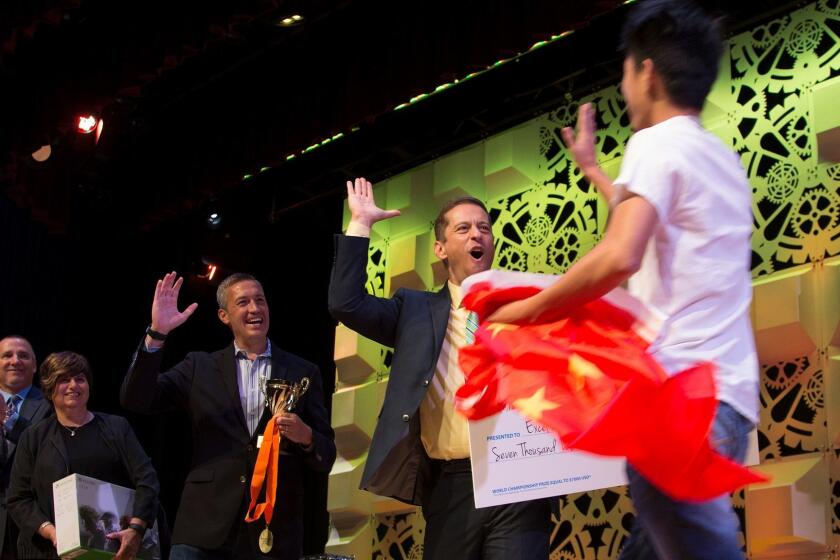ANAHEIM, CA - AUGUST 2, 2017 : JiaXi Dai of China gets a high five from Aaron Osmond, general manager at Certiport, middle, after being named Excel 2013 First Place Champion during the awards ceremony for the Microsoft Olympics at the Disneyland Hotel on August 2, 2017 in Anaheim, California. Six U.S. high school students tested their skills on PowerPoint, Word and Excel competing against the finalists in countries across the world during the three-day competition.(Gina Ferazzi / Los Angeles Times)