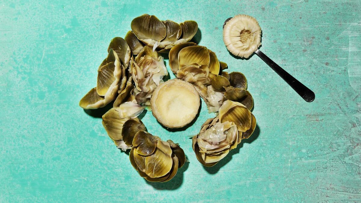 Use a spoon to scoop out the hairy choke from the hearts of large, mature globe artichokes.