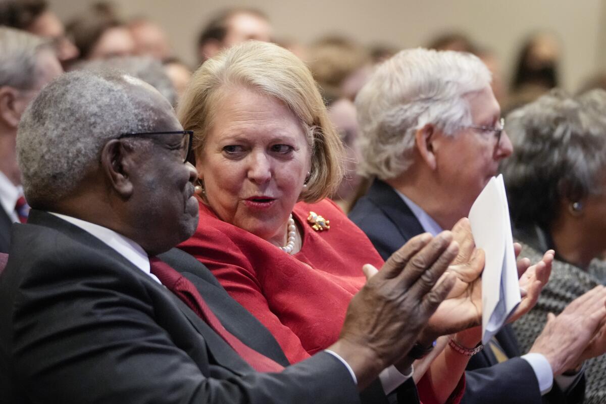 Clarence Thomas and Virginia Thomas talk to each other.