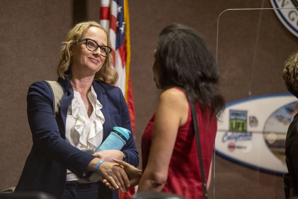Huntington Beach City Council member Natalie Moser congratulates Rhonda Bolton after she was sworn in Monday night.
