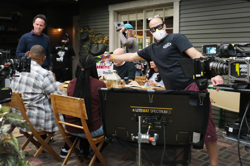 Behind the scenes on the set of THE UNICORN on CBS shot in January of 2021. Pictured: Rob Corddry as Forrest, Michaela Watkins as Delia, Walton Goggins as Wade(standing), Maya Lynne Robinson as Michelle, Omar Miller as Ben. Episode: “Out with the Old” – Wade, Forrest and Ben decide to schedule colonoscopy appointments at the same time after they learn that Ben is scared to go. Also, Michelle tries to avoid her sister Meg’s (Nicole Byer) boyfriend drama, but Delia winds up getting over-involved in Meg’s issues, on THE UNICORN, Thursday, March 11 (9:30-10:00 PM, ET/PT) on the CBS Television Network. Photo: Patrick Wymore/CBS ©2021 CBS Broadcasting, Inc. All Rights Reserved.