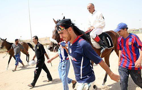 A jockey heads to the track at the Baghdad Equestrian Club, where Iraqis check political and religious tensions at the door.More photos >>>