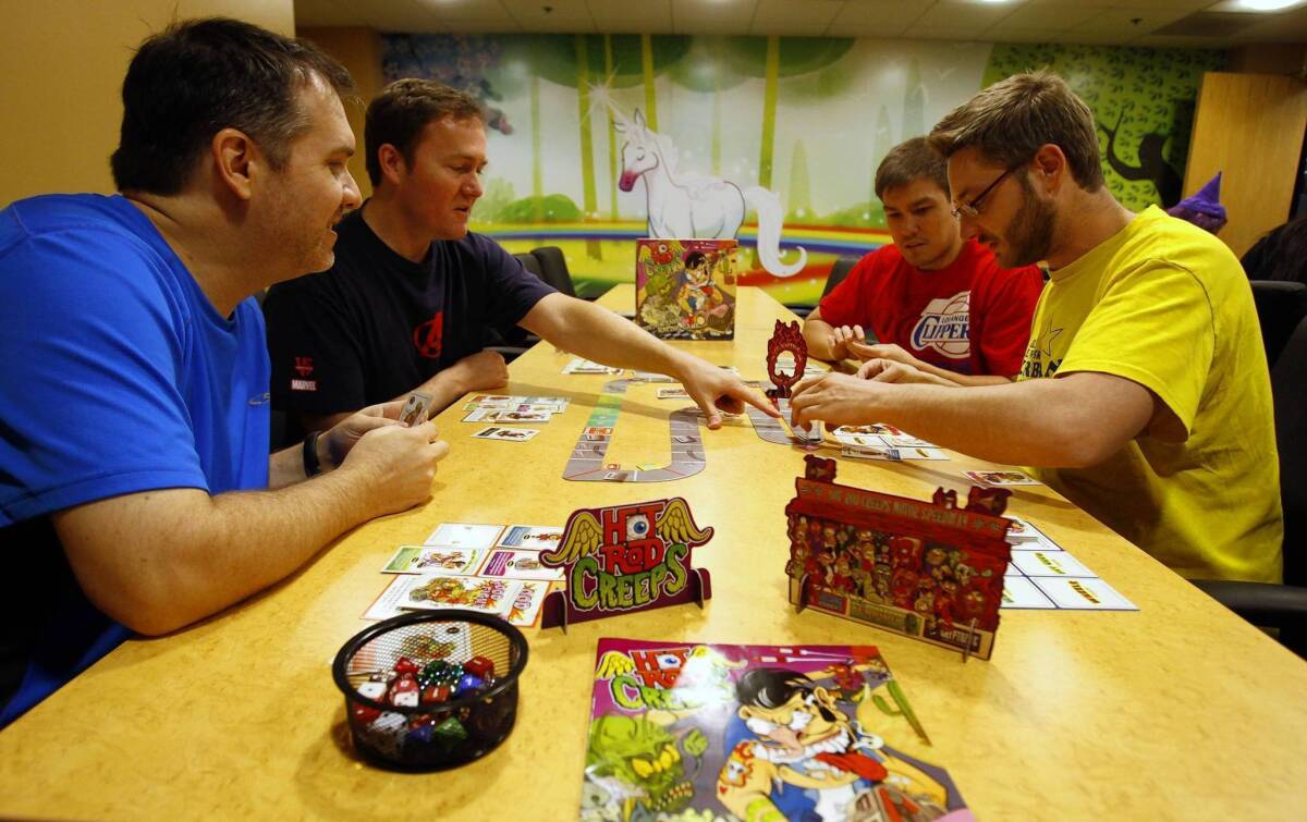 From left: Kyle Heuer, Matt Hyra, Will Brinkman and Phil Cape play Hot Rod Creeps, a card-driven racing game, at Cryptozoic Entertainment in Irvine, California.