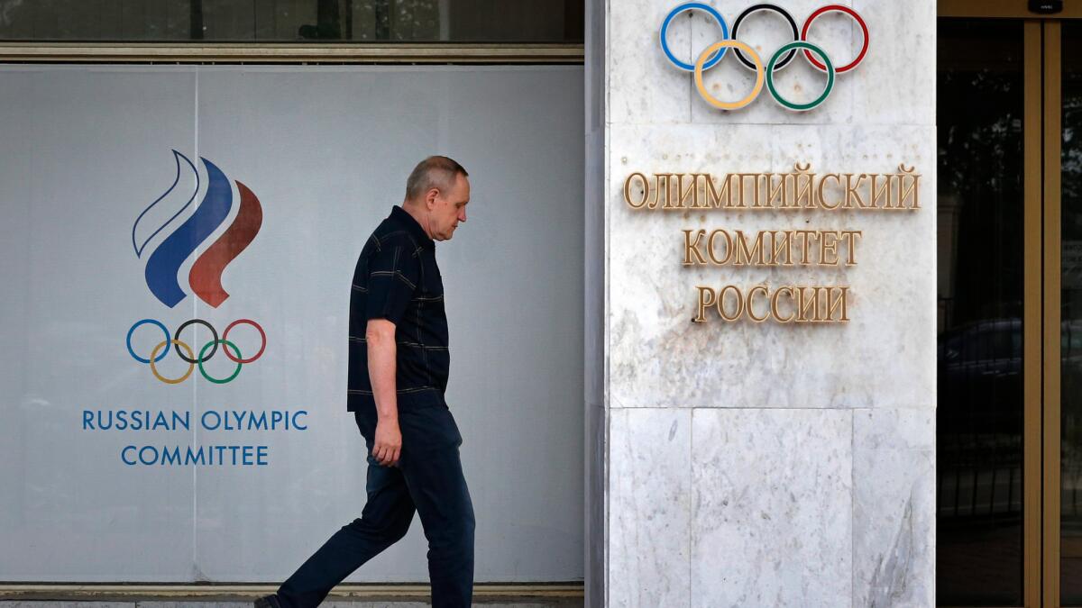 A man walks in front of the Russian Olympic Committee headquarters and Russian Athletics Federation office in Moscow on July 19.