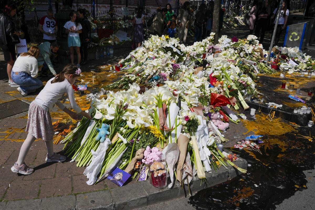 Girl laying flowers for victims of mass shooting at Serbian school