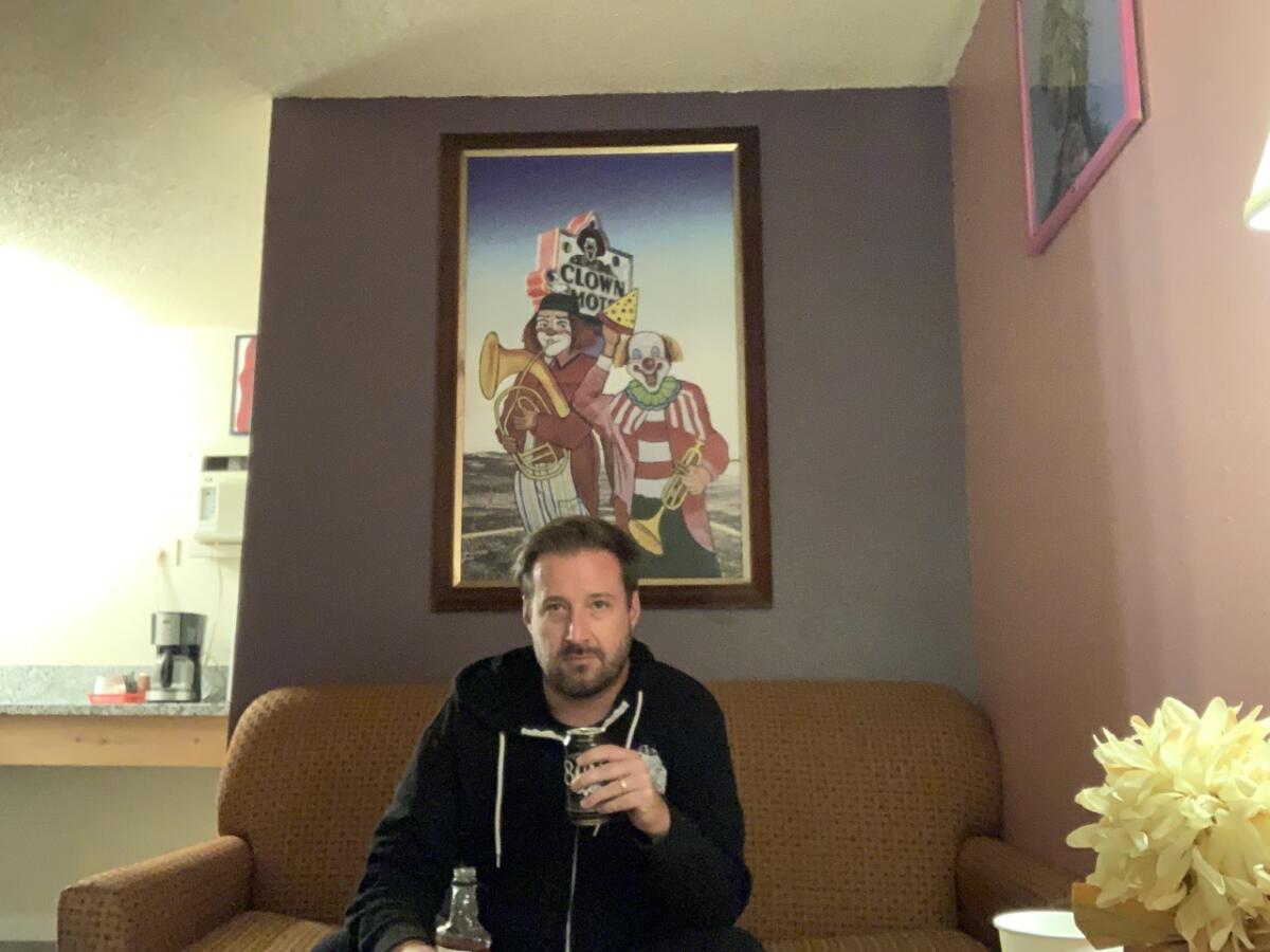 A man sitting inside the relatively nice Clown Motel suite.