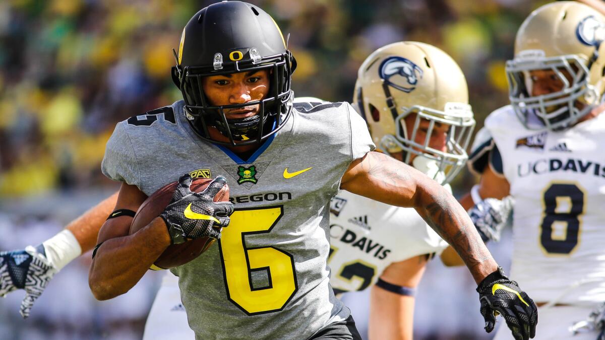 Oregon receiver Charles Nelson leaves a pair of UC Davis defenders behind while running for a two-point conversion Saturday.
