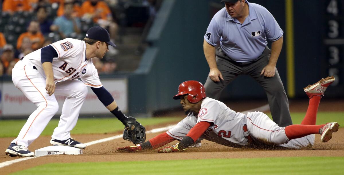 Angels shortstop Erick Aybar is tagged out by Astros third baseman Jed Lowrie while trying to take two bases on a wild pitch.