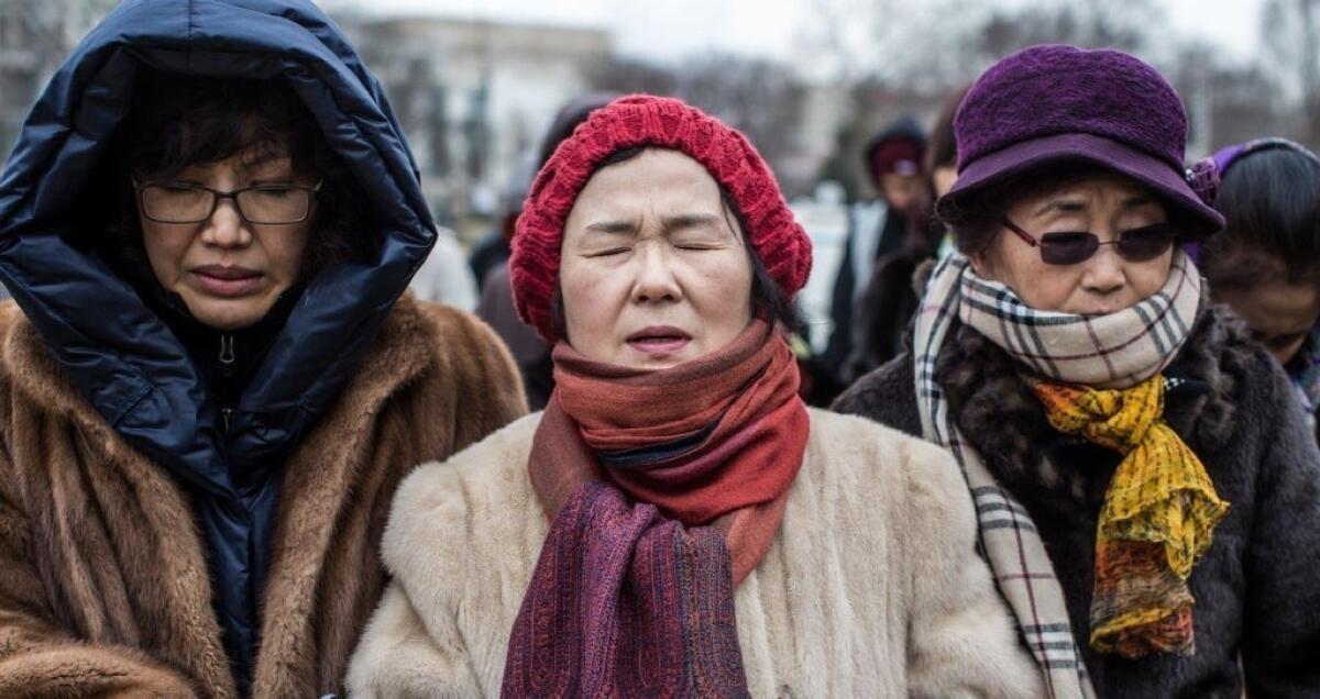 Abortion opponents Grace Jang, Sharon Lee and Virginia Kim, all from Springfield, Va., pray before an anti-abortion march Friday in Washington.
