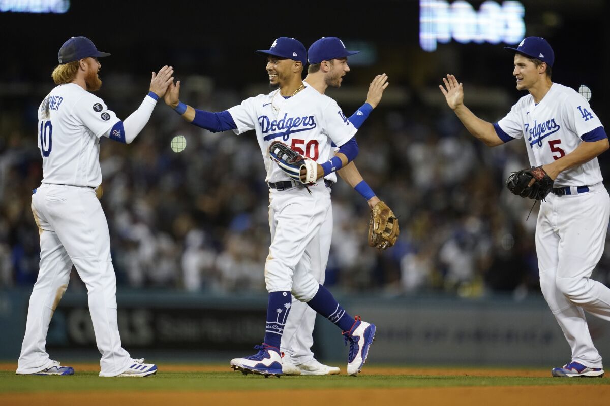From left, Los Angeles Dodgers third baseman Justin Turner (10), right fielder Mookie Betts (50), second baseman Trea Turner (6), and shortstop Corey Seager (5) celebrate after a 3-0 win over the San Diego Padres in a baseball game Friday, Sept. 10, 2021, in Los Angeles. (AP Photo/Ashley Landis)