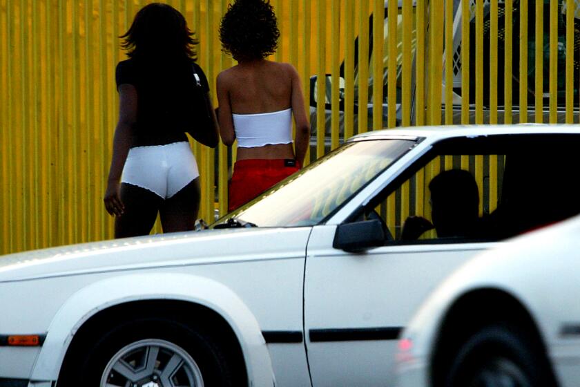 LOS ANGELES, CALIF. - APR. 9, 2020. Women walk along Figueroa Street in South Los Angeles, in an area whee the highest number of prostitution-related arrests in the city are made. (Luis Sinco/Los Angeles Times)