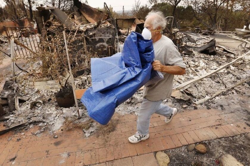 Victor Lobl usa lonas y bolsas de arena para prepararse para una inminente tormenta. (Al Seib / Los Angeles Times)