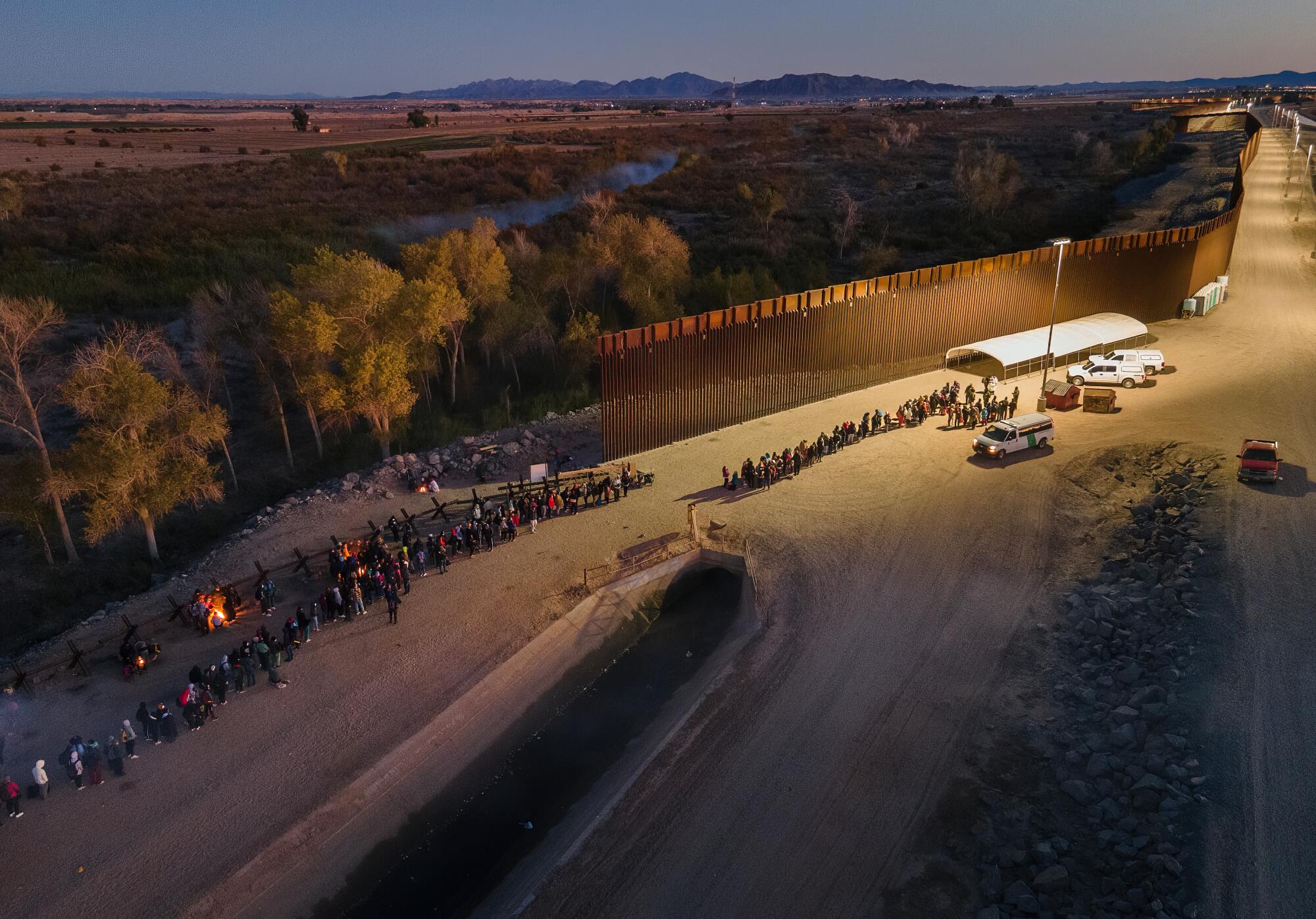 A group of 200 migrants wait in a long line to be processed by U.S. Border Patrol agents south of Yuma, Ariz.