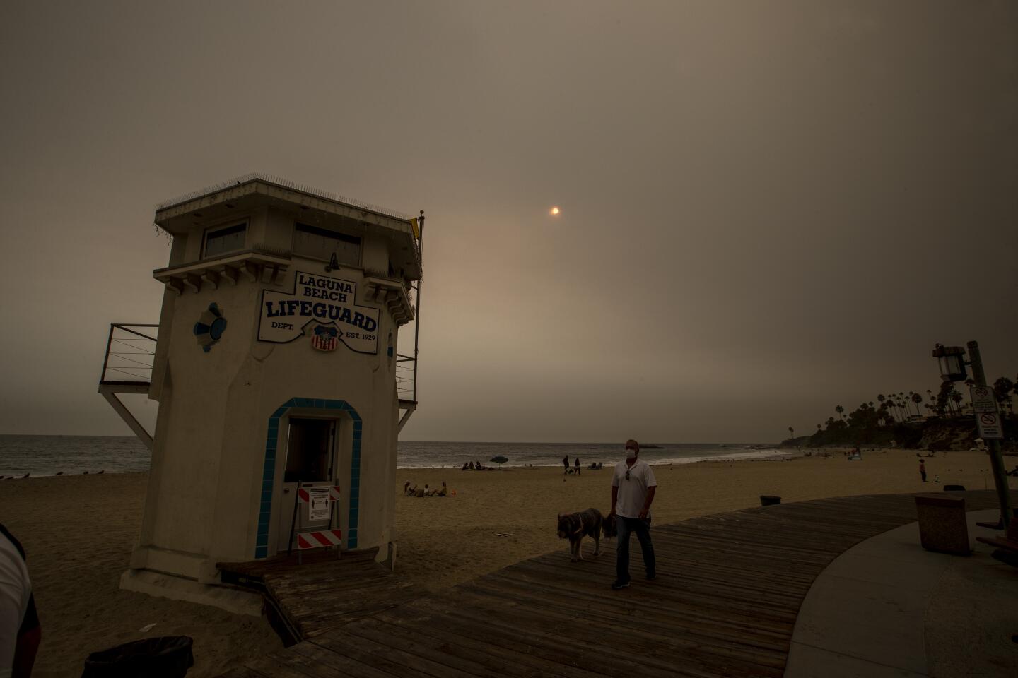 A man walks his dog past the historic lifeguard tower in Laguna Beach.