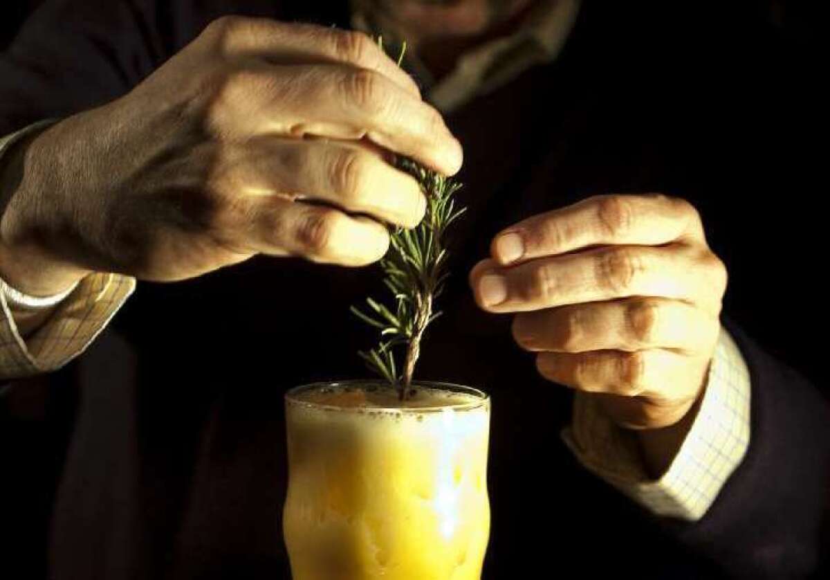 Bartender Matthew Biancaniello garnishes a hops-infused-gin cocktail with a sprig of rosemary.