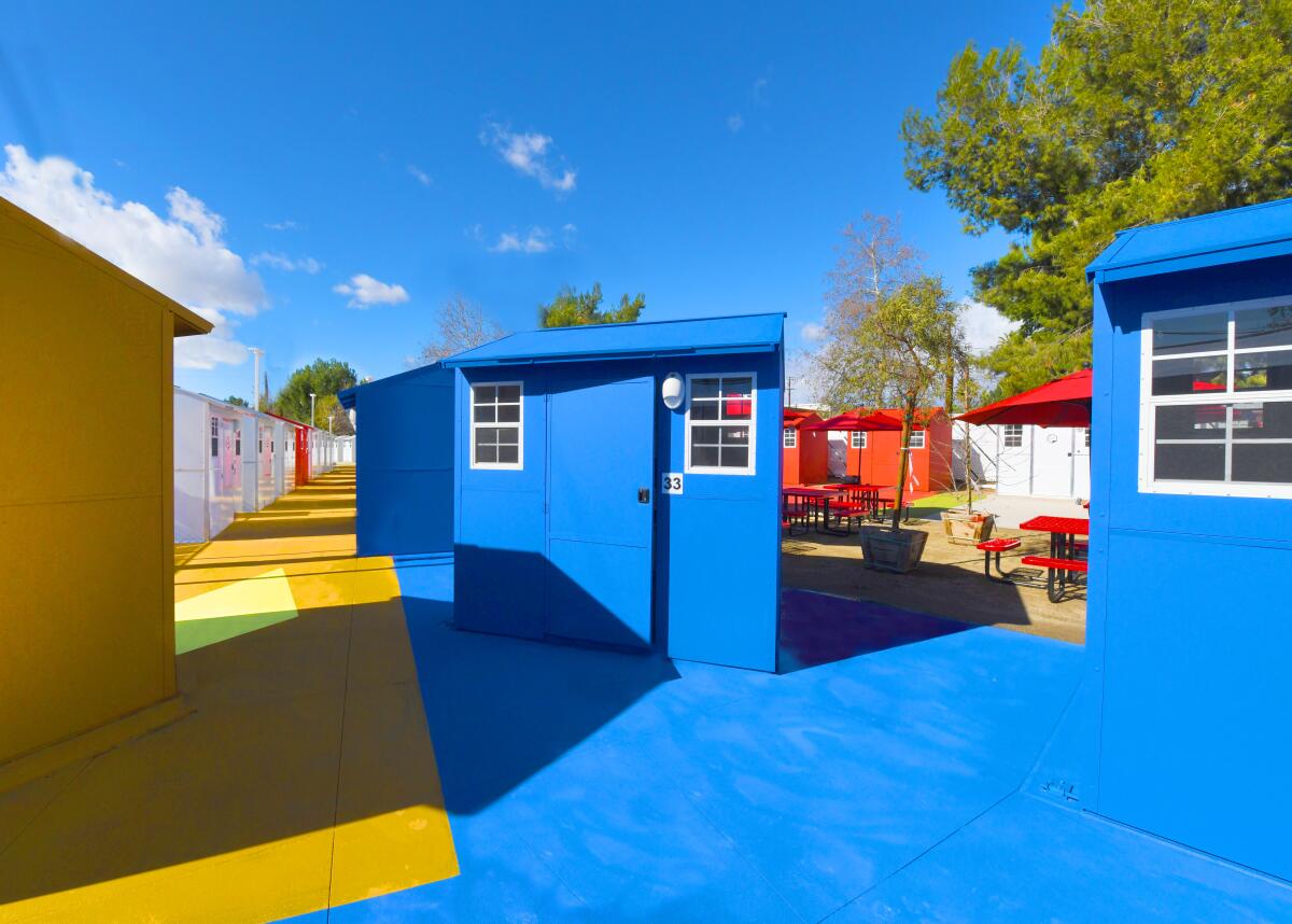 Tiny homes are painted bright hues of blue and yellow