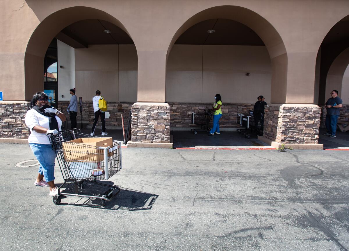 Shoppers are socially distanced in a line outside a Ralphs in Westchester on March 22.