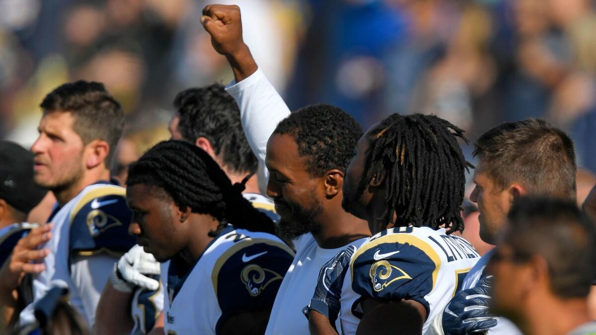Robert Quinn raises his fist during the playing of the national anthem before a preseason game this year.