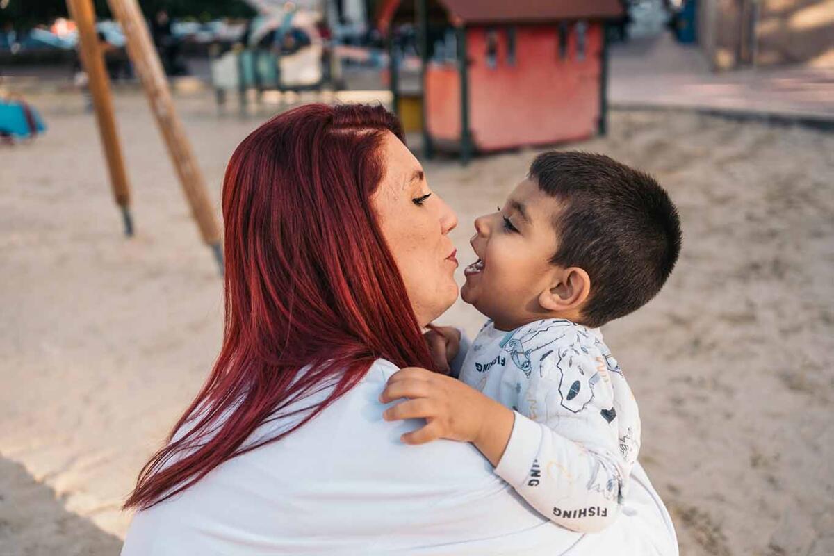 Affectionate embrace between mother and autistic son in playground
