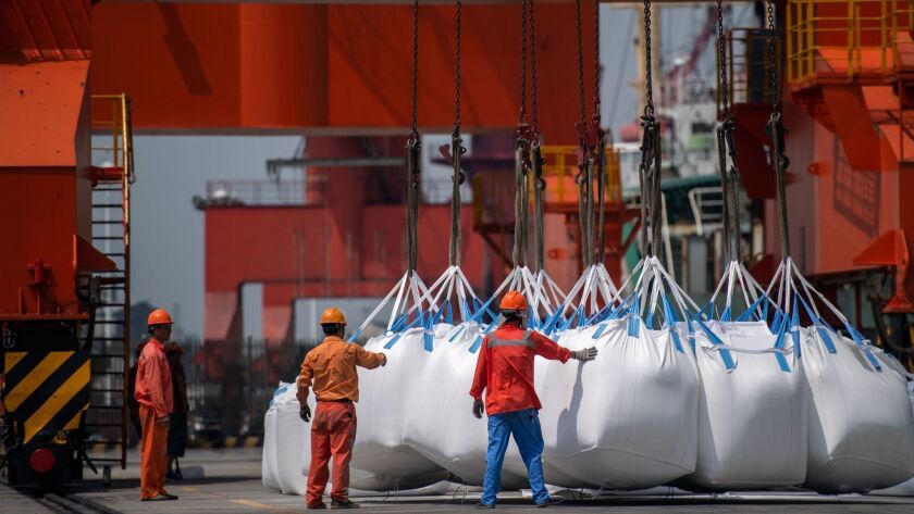 The biggest risks to U.S. economic growth are “over-leveraged corporations and escalating trade tensions, especially with China,” a UCLA forecast said. Above, port workers in China.