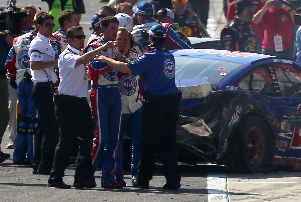 Joey Logano is held back by crew members after an altercation on track with Tony Stewart (not pictured) after the NASCAR Sprint Cup Series Auto Club 400 in Fontana on March 24.