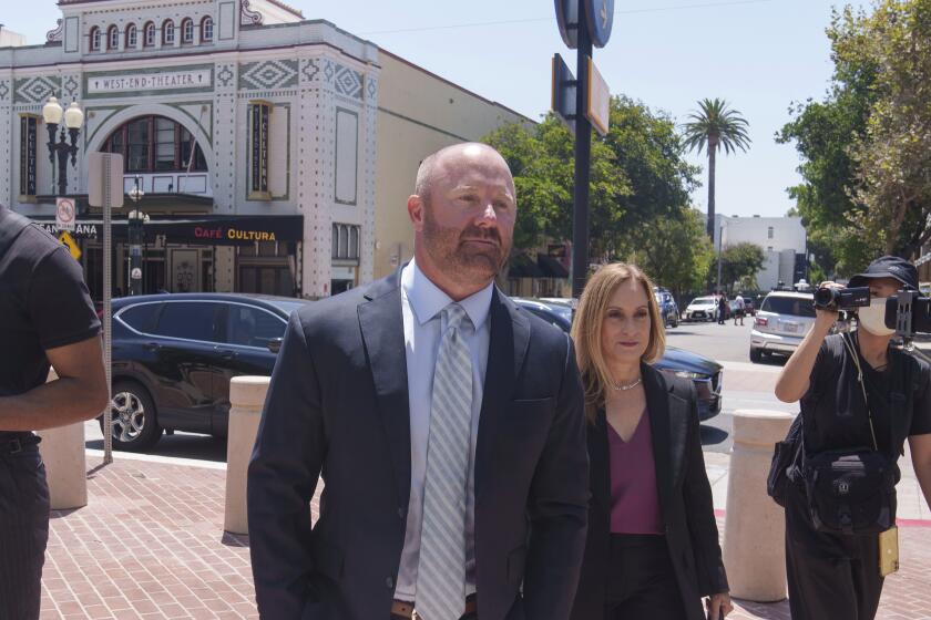 Mathew Bowyer, izquierda, corredor de apuestas del sur de California, llega acompa?ado por su abogada, Diane Bass, derecha, a un tribunal federal en Santa Ana, California, el viernes 9 de agosto de 2024. (AP Foto/Damian Dovarganes)