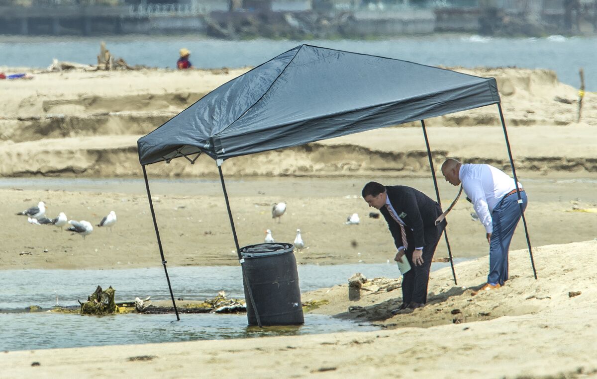 MALIBU, CA-JULY 31, 2023: Lt. Hugo Reynaga, left, and Sgt. Arias (didn't give first name) of the Los Angeles County Sheriff's Department investigate the scene at the Malibu Lagoon, where a body was found inside a 55-gallon drum. According to Lt. Hugo Reynaga, a lifeguard noticed the 55-gallon drum floating in the middle of the lagoon this morning and after getting it to shore and opening up the lld, discovered a lifeless human body inside. (Mel Melcon / Los Angeles Times)