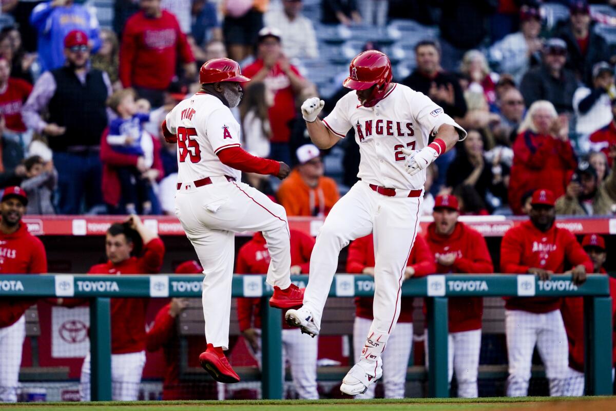 Mike Trout celebrates his home run with third base coach Eric Young Sr. during the first inning.