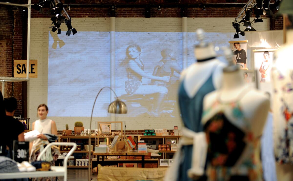 Kara McCulloh, store merchandiser at Urban Outfitters on Broadway in downtown Los Angeles, straightens items in a storefront window on Tuesday, June 28, 2016.