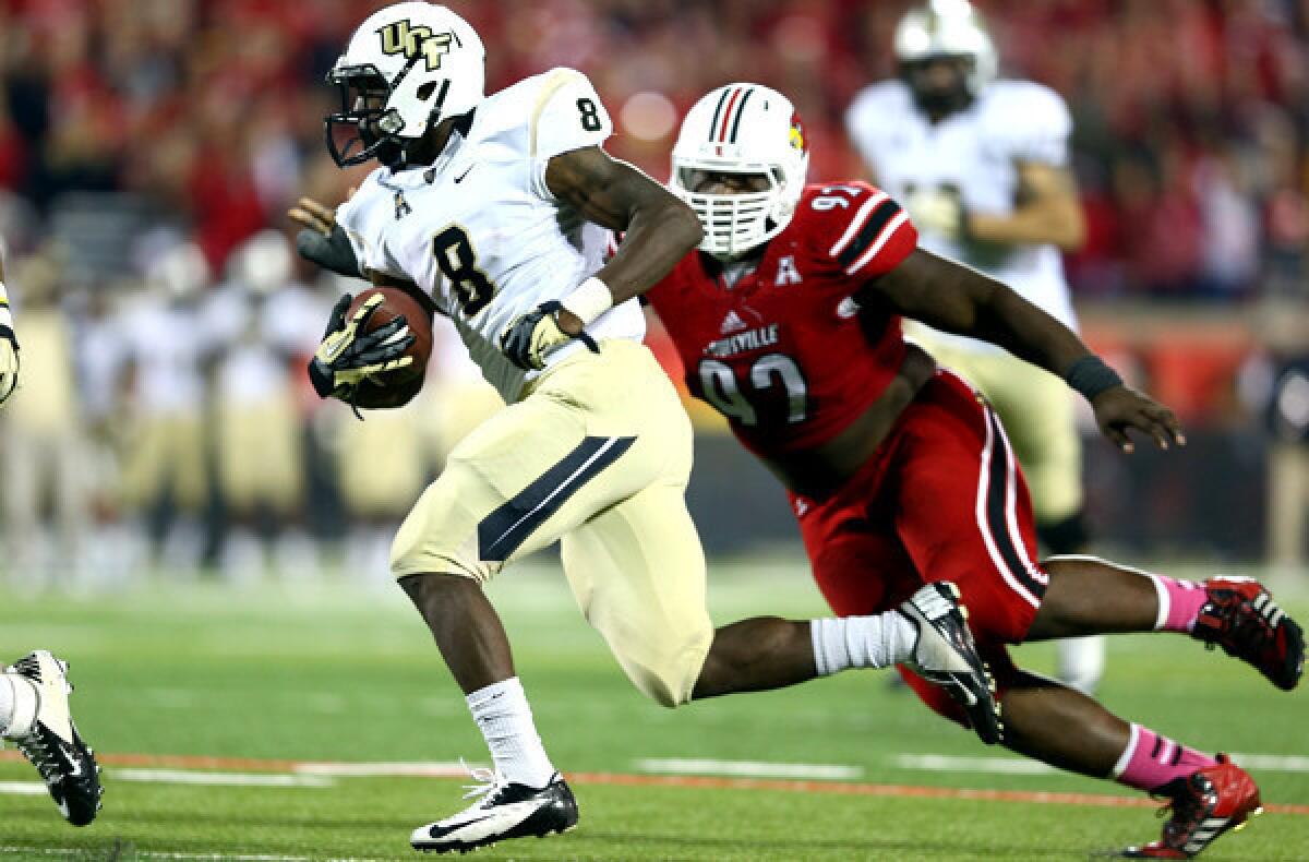 Central Florida running back Storm Johnson evades Louisville defensive tackle Brandon Dunn on a touchdown run during their game Friday night.