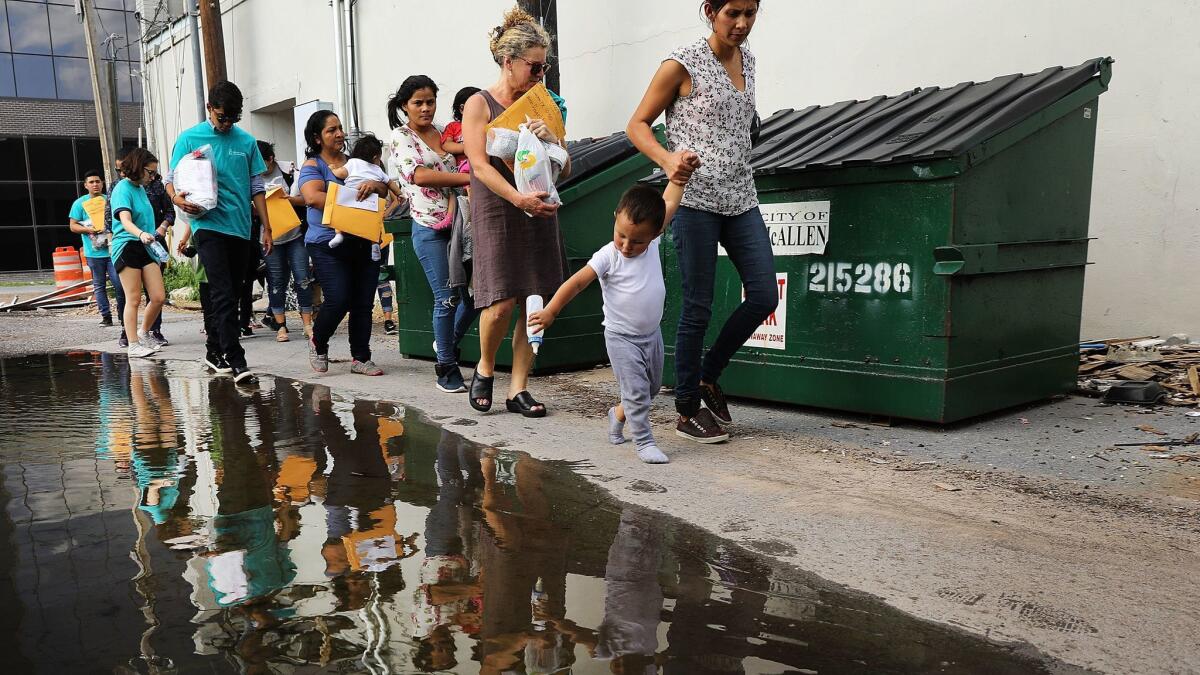 Volunteers walk dozens of women and their children to a relief center following their release from Customs and Border Protection on June 22 in McAllen, Texas.