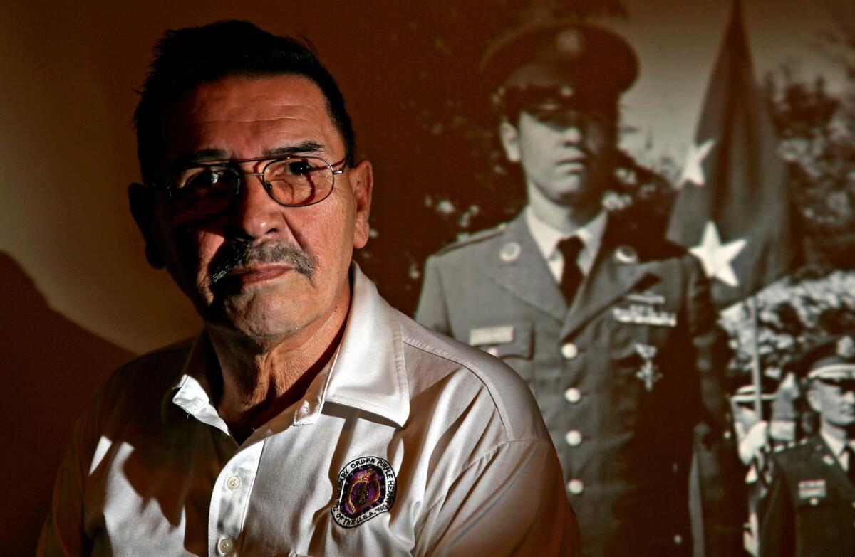 Erevia at home in San Antonio. An image of his younger self is projected behind him. He never dwelt on not receiving the Medal of Honor. He moved on with his life and became a mail carrier, retiring in 2002 after 32 years at the Postal Service.