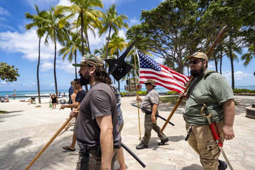 Members of Hawaii Firearms Coalition walk around Waikiki with their non-firearm weapons on Saturday, June 22, 2024, in Honolulu, Hawaii. (AP Photo/Mengshin Lin)