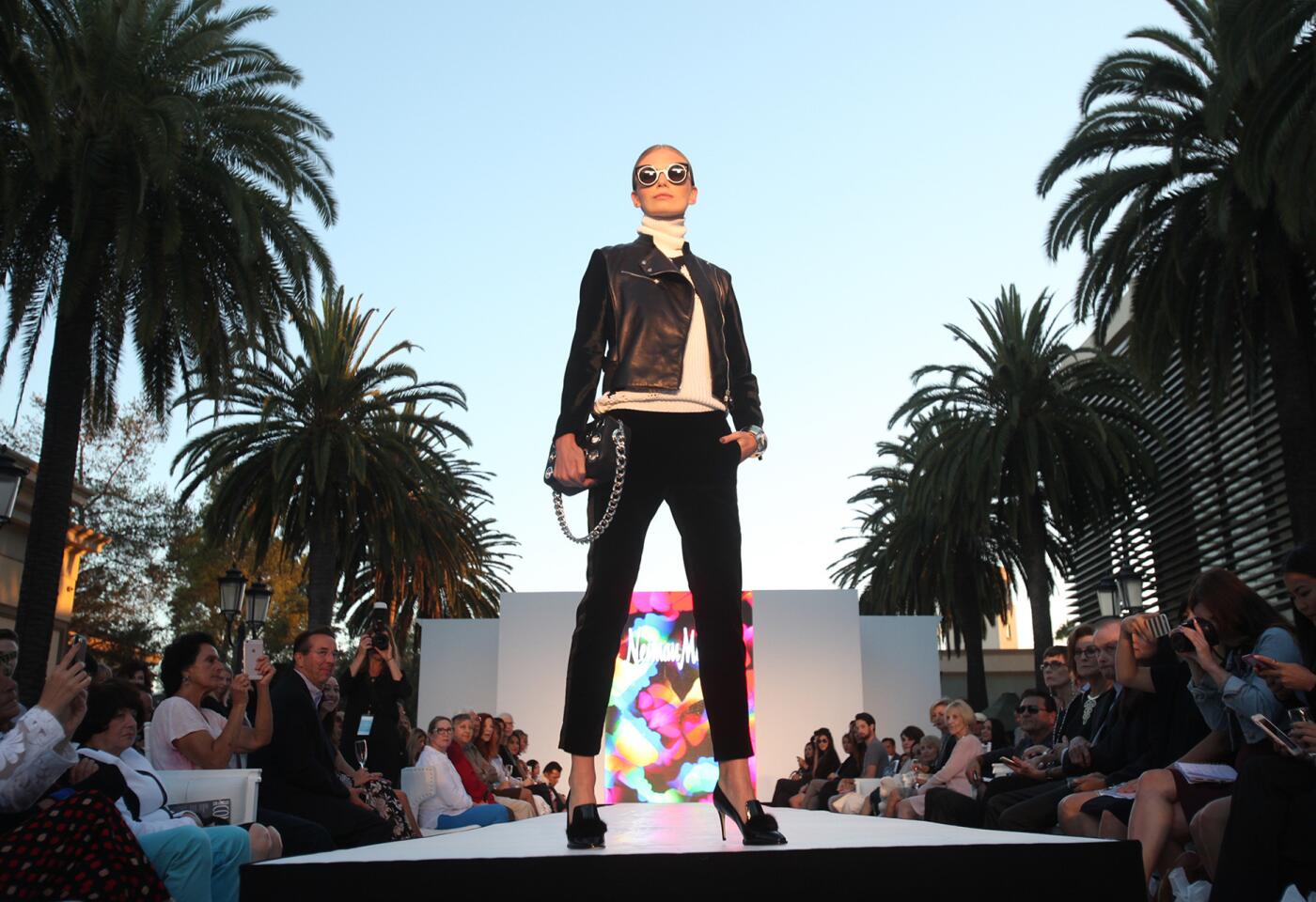 A model shows off the latest fashions from Neiman Marcus during STYLE WEEK OC runway fashion show at Fashion Island on Thursday. The event showcased fall trends inspired by various themes including shades of berry, fall florals, and Military-inspired pieces that featured popular bomber jackets.