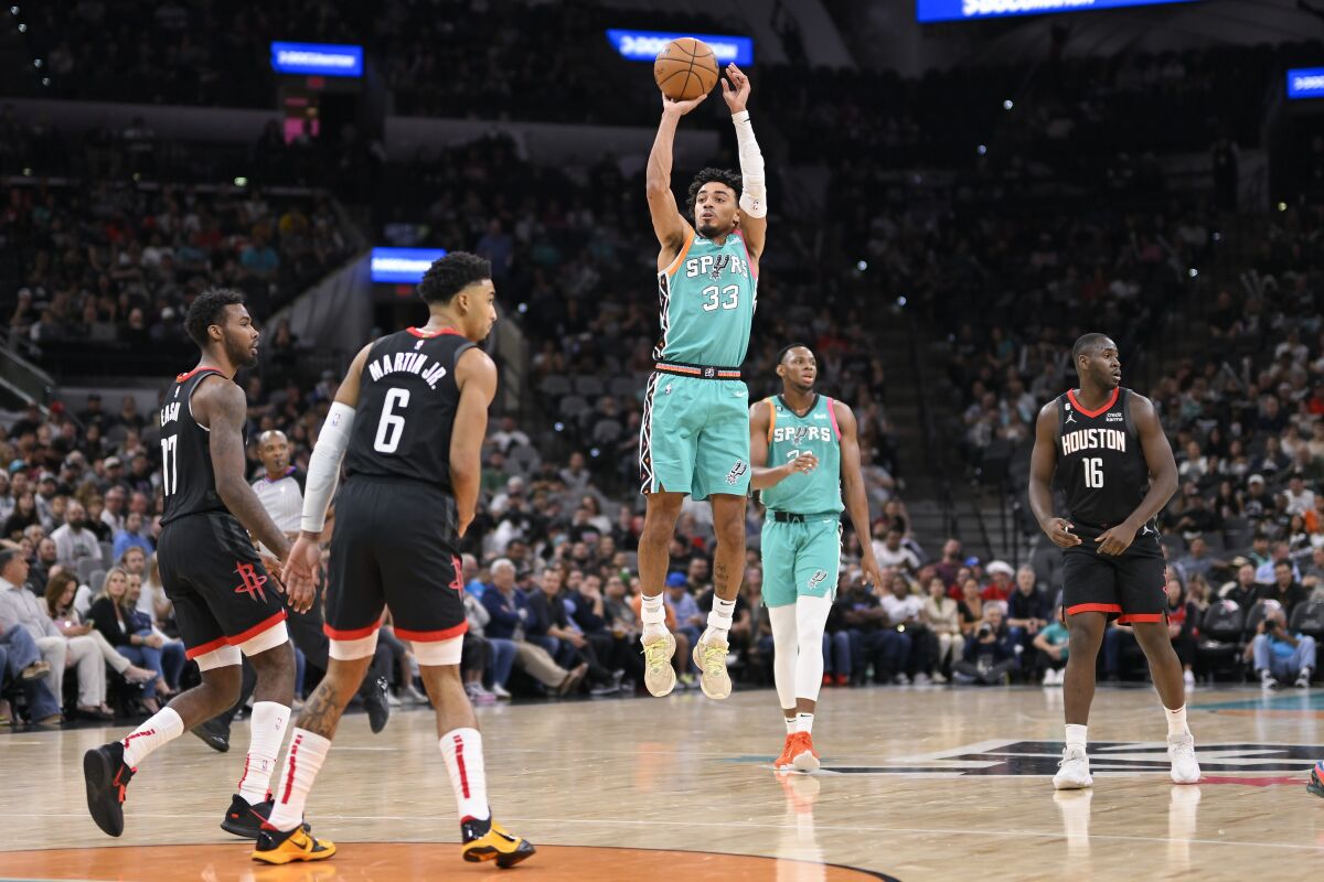 Tre Jones (33), de los Spurs de San Antonio, efectúa un lanzamiento en la segunda mitad del partido contra los Rockets de Houston, en la segunda mitad del partido de la NBA en San Antonio, el jueves 8 de diciembre de 2022. (AP Foto/Darren Abate)