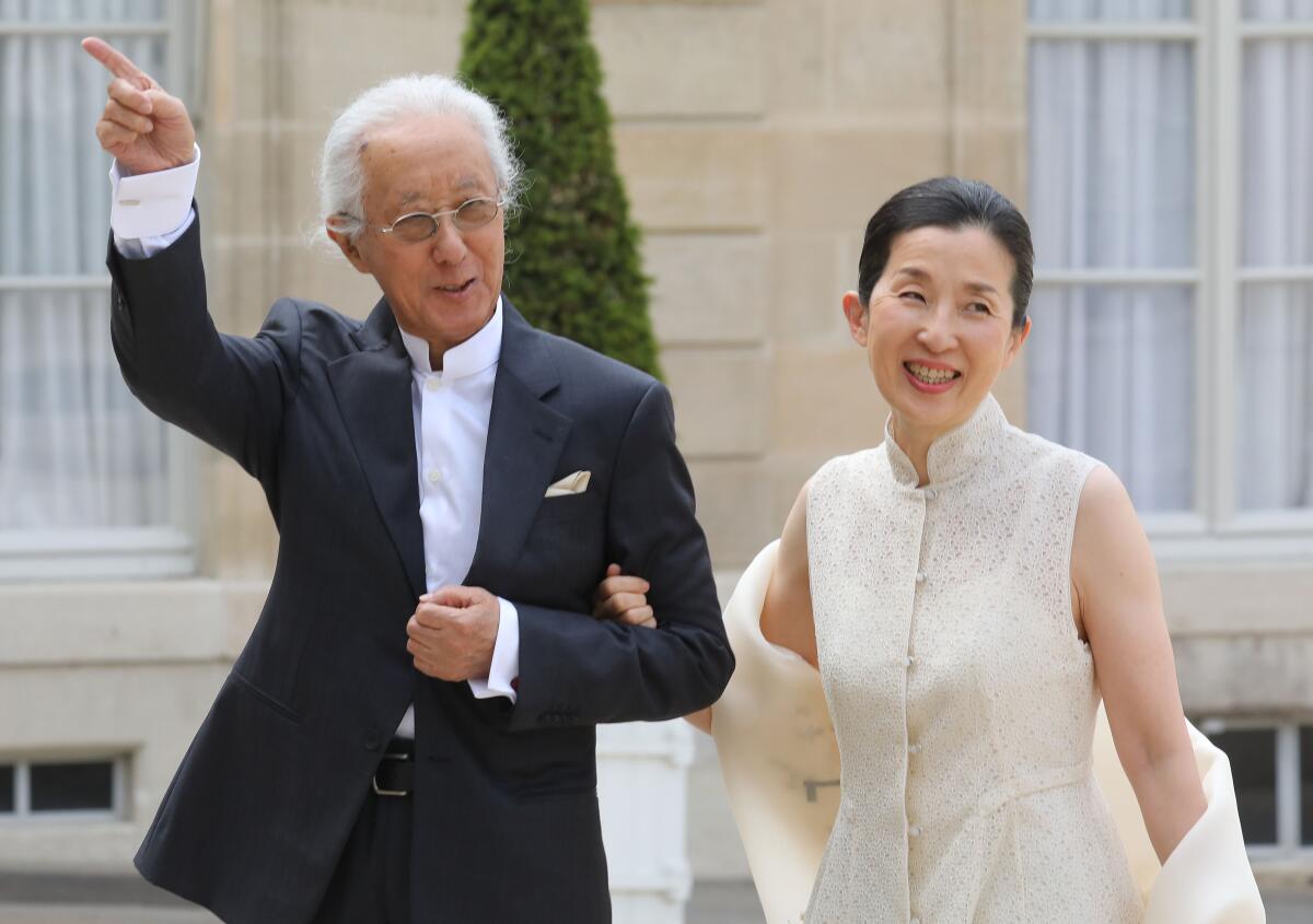 Japanese architect Arata Isozaki, in a black suit, arrives at the Pritzker ceremony with Misa Shin, in a cream dress.