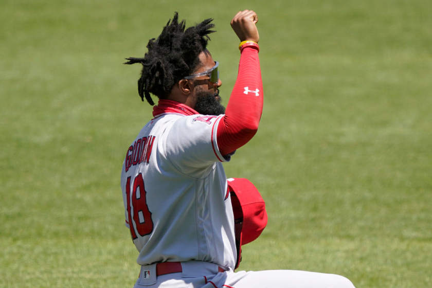 Angels outfielder Brian Goodwin takes a knee and raises his fist during the playing of the national anthem.