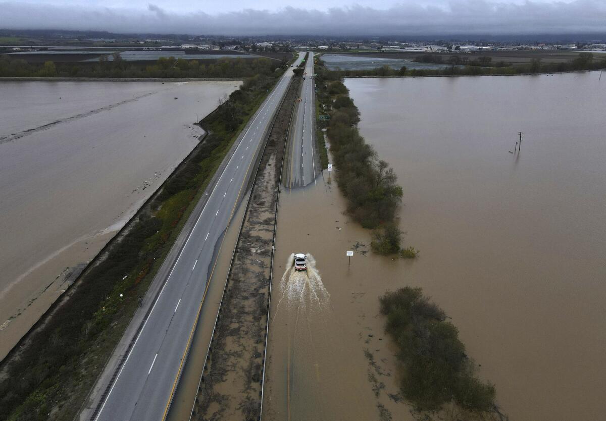 A CalTrans vehicle drives north through floodwaters that closed state Highway 1 at the Santa Cruz County line