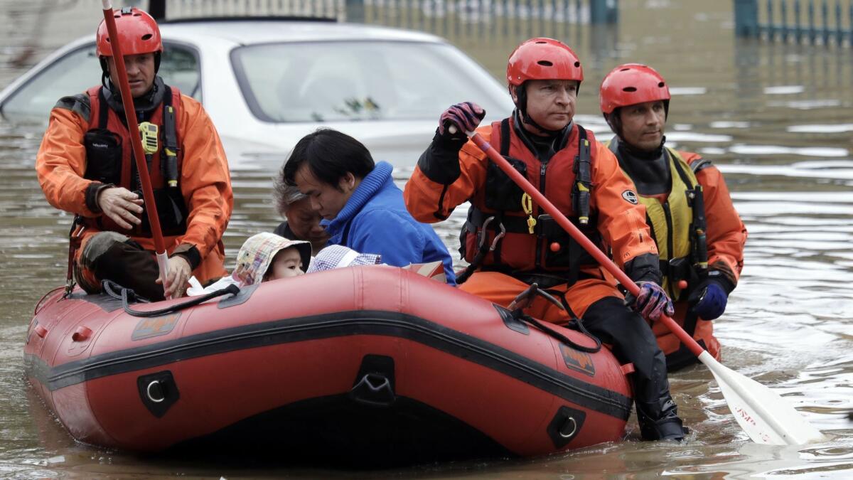 Rescuers steered boats carrying dozens of people, some with babies and pets, from a San Jose neighborhood inundated by water from an overflowing creek Tuesday.