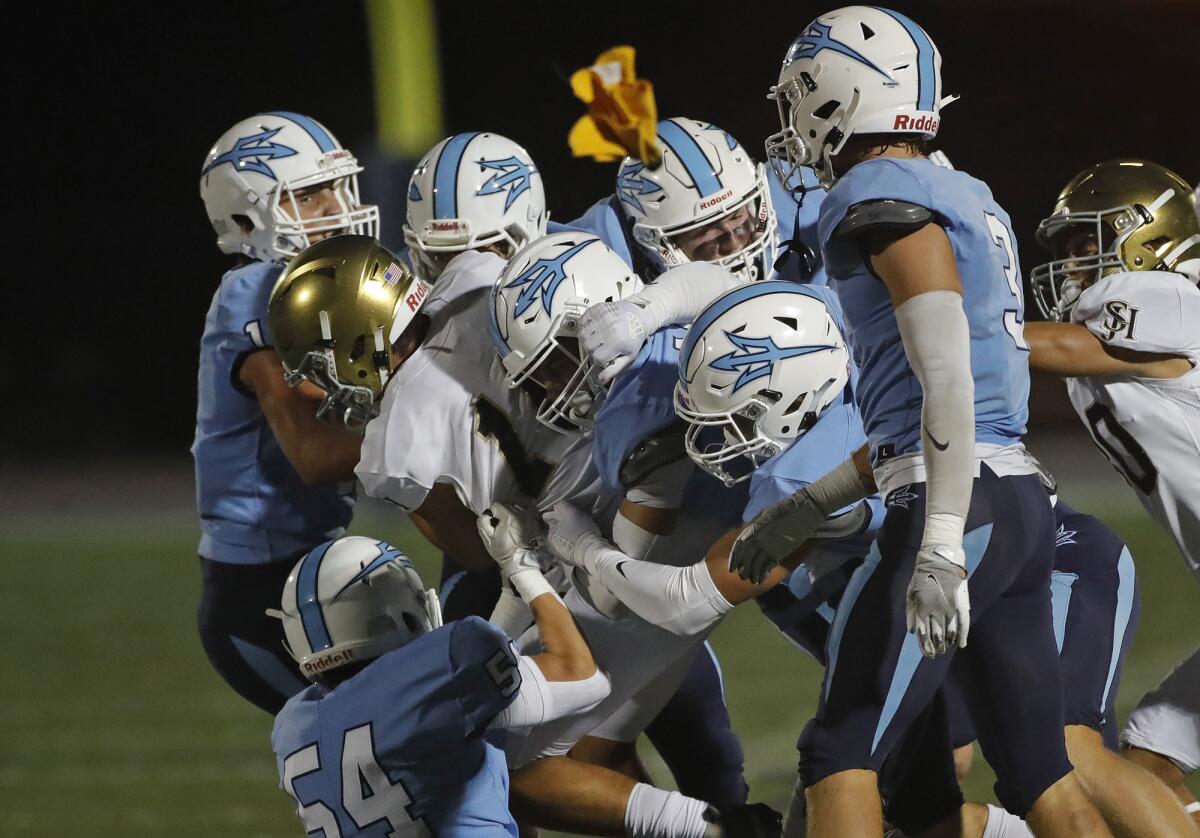 A host of Corona del Mar defenders bring down San Juan Hills quarterback Michael Tollefson on Thursday at Davidson Field.