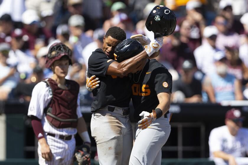 Tennessee's Christian Moore, left, hugs Dylan Dreiling at home plate after Dreiling hit a two-run home run against Texas A&M in the seventh inning of Game 2 of the NCAA College World Series baseball finals in Omaha, Neb., Sunday, June 23, 2024. (AP Photo/Rebecca S. Gratz)