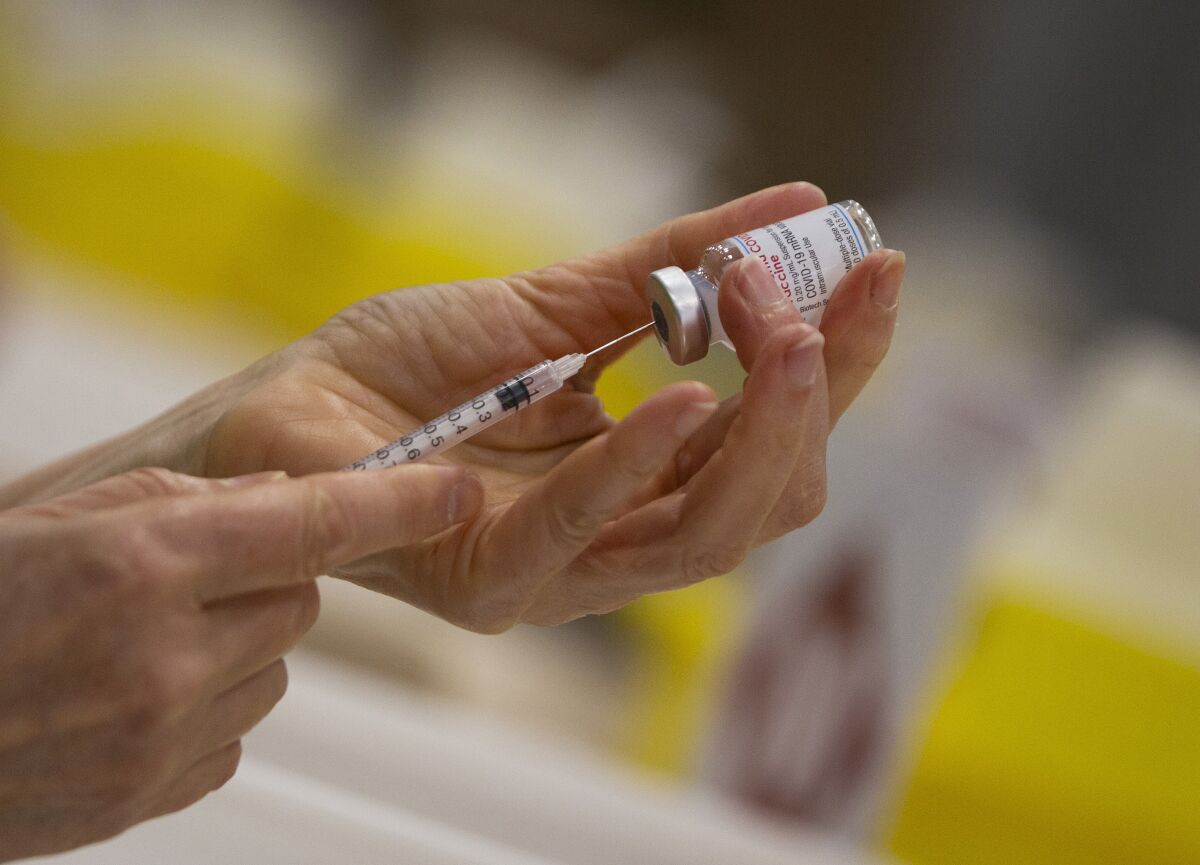 FILE - In this file photo dated Wednesday, April 14, 2021, a pharmacist fills a syringe from a vial of the Moderna COVID-19 vaccine in Antwerp, Belgium. Moderna and vaccine promoter Gavi have announced Monday May 3, 2021, the pharmaceutical company will provide up to 500 million coronavirus vaccine doses for the U.N.-backed program for needy people in low- and middle-income countries by the end of 2022. (AP Photo/Virginia Mayo, FILE)