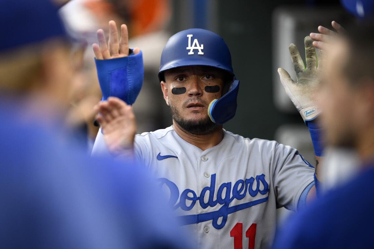 Miguel Rojas celebrates in the dugout after scoring a run for the Dodgers against the Baltimore Orioles.