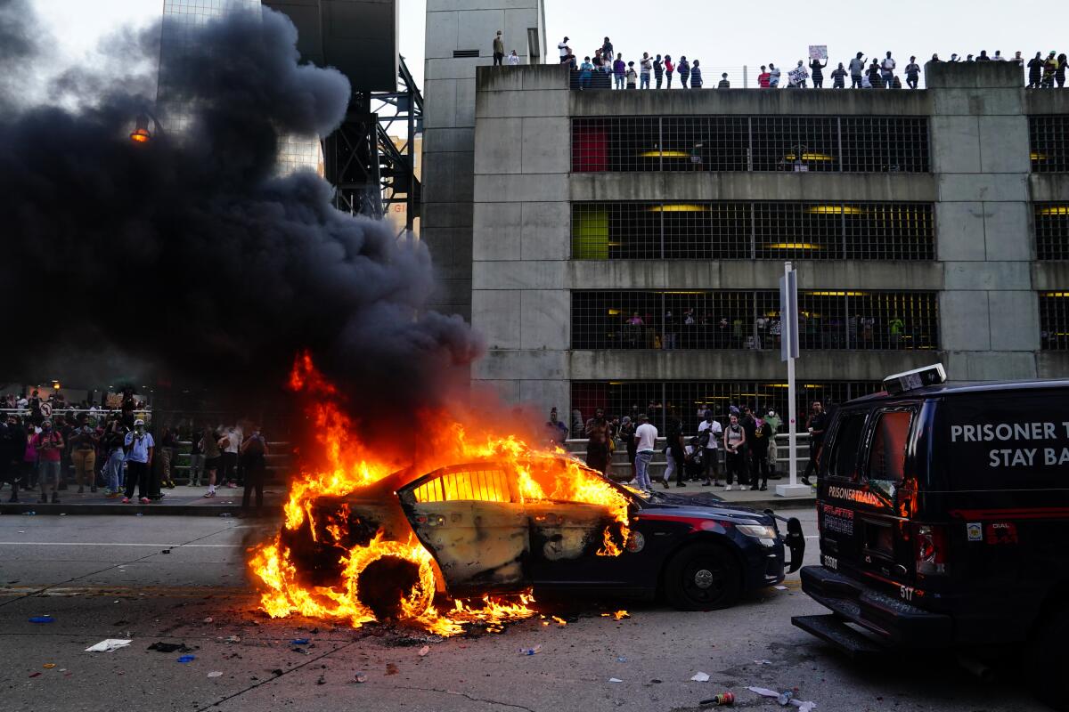 A burning police car is seen during a protest on May 29, 2020 in Atlanta, Georgia.