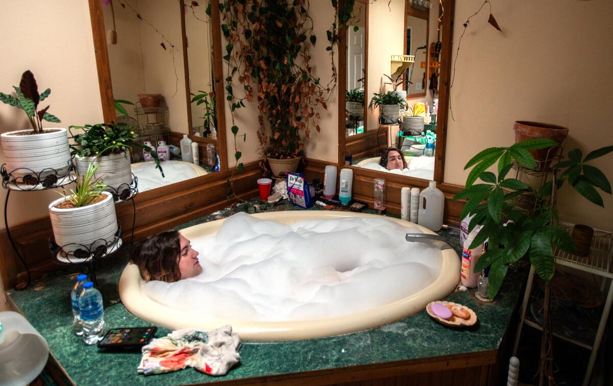 A woman relaxes in a bubble bath.