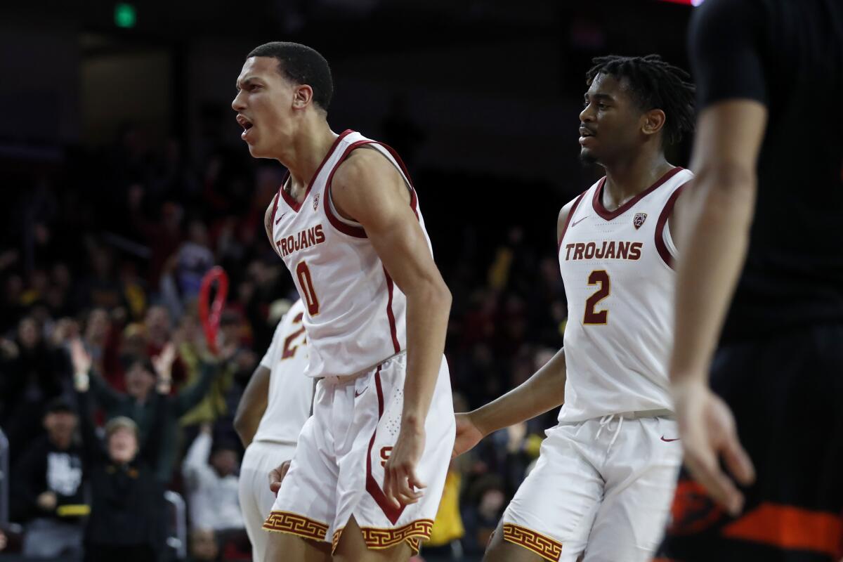 USC forward Kobe Johnson, left, reacts to making a basket against Oregon State with guard Reese Dixon-Waters.